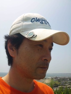 白い帽子をかぶってオレンジのTシャツを着ている前田歩の顔のアップ