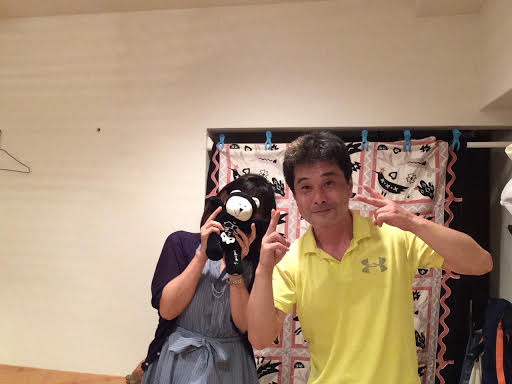 熊のぬいぐるみで顔を隠したエレガントな女性のお客様と前田歩の笑顔のツーショット写真