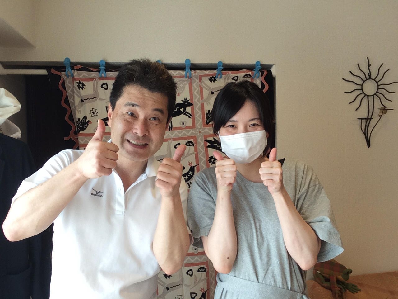 ぎっくり腰が治ってお喜びのマスクをした若い女性のお客様と前田歩の笑顔のツーショット