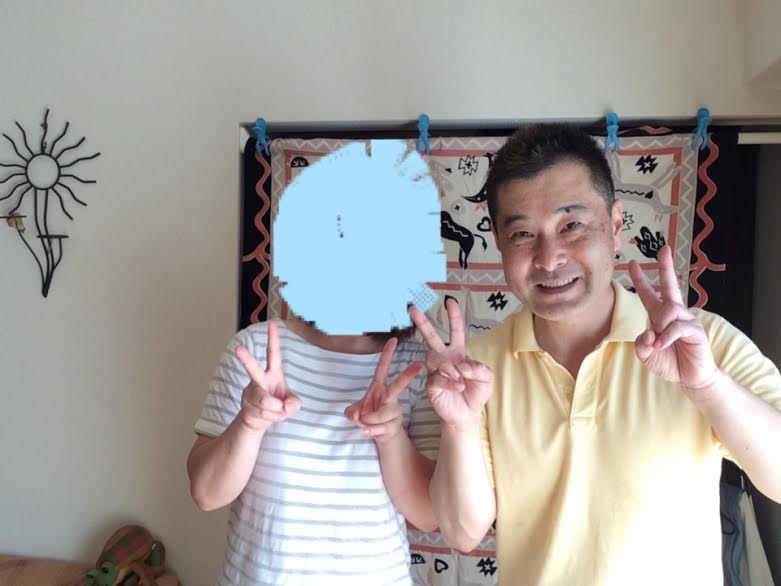 肩こり腰痛が改善してお喜びの白いボーダーのTシャツを着た女性のお客様と前田歩の笑顔のツーショット