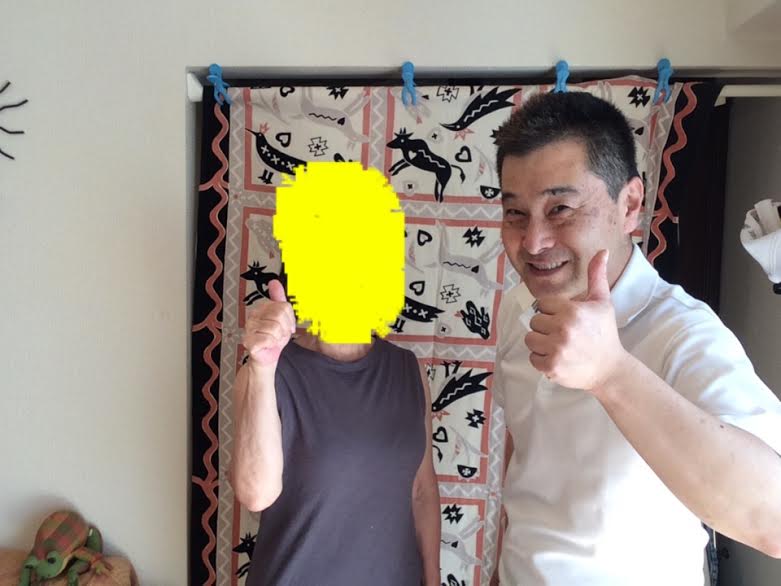 肩こりが改善してお喜びの黒いノースリーブのTシャツを着た女性のお客様と前田歩の笑顔のツーショット