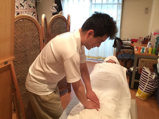 前田歩の女性のお客様への整体マッサージ仰向けで脚への施術風景