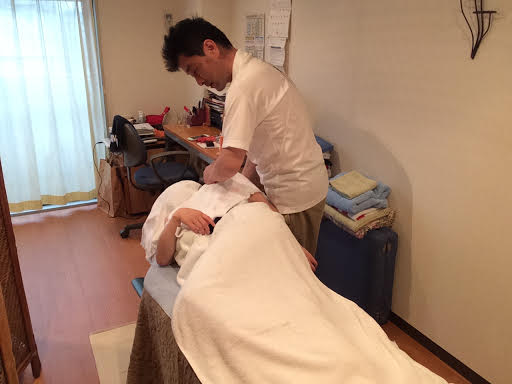 ボディケア前田にて女性のお客様の左肩甲骨周辺を横向きで整体マッサージ施術する前田歩