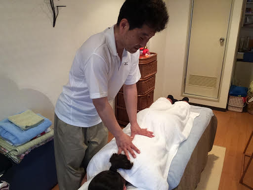 ボディケア前田にて女性のお客様の右背中の整体マッサージ施術中の前田歩