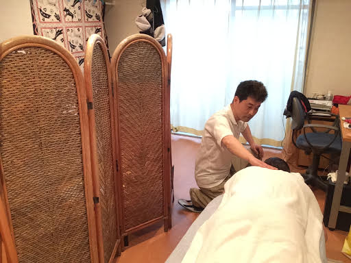 ボディケア前田にて女性のお客様の右首すじの整体マッサージ施術中の前田歩